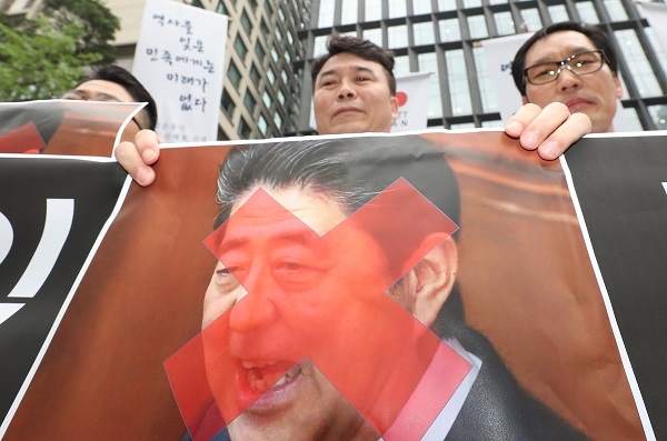 15일 서울 종로구 옛 일본대사관 앞에서 열린 일본제품 판매중단 확대선포 기자회견에서 한 참석자가 'X'표시가된 일본 아베총리 사진을 들고 있다. 사진=연합뉴스