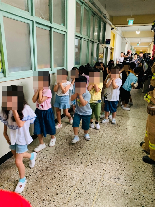 25일 서울 구로구의 한 초등학교에서 학생들이 코와 입을 가린 채 건물 밖으로 대피하고 있다(사진=연합뉴스,구로소장서제공)