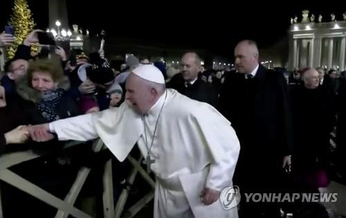 지난달 31일 성 베드로 광장에서 프란치스코 교황이 한 신도가 손을 잡아 당기자 얼굴을 찡그리고 있다. 사진=연합뉴스