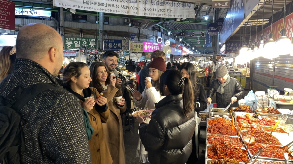 광장시장에 방문해 전통 길거리 음식을 체험하고 있는 외국인 디지털 노마드 행사 참가자들. [사진=한국관광공사]